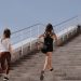 Two women running up stairs outdoors, embodying fitness and wellness.